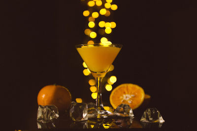 Close-up of wine glass against illuminated lamp