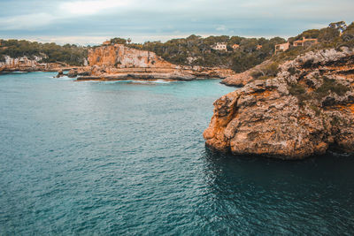 Rock formations in sea against sky