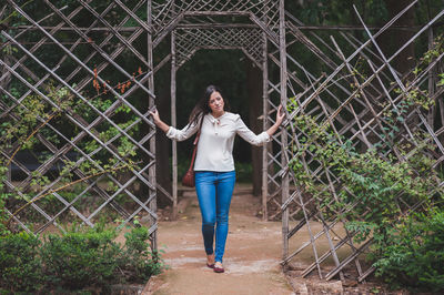 Full length of young woman standing by railing