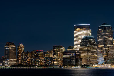 A view of the city skyscrapers with their lights on in the night.