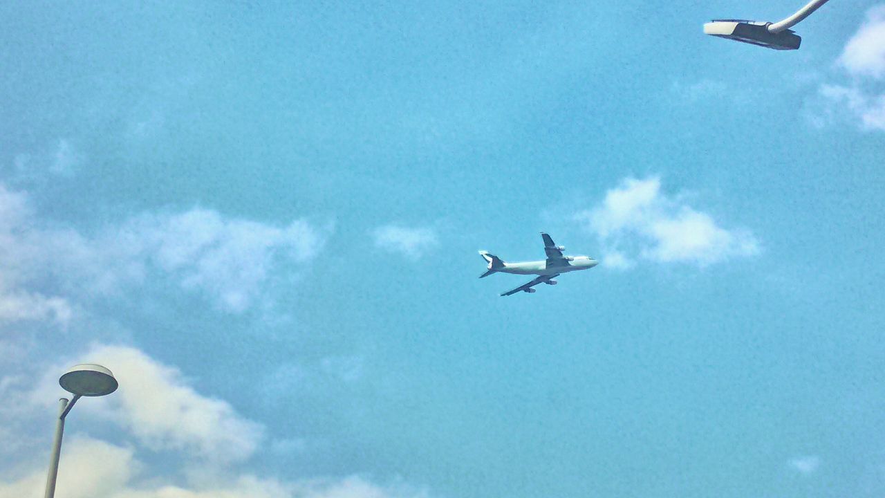 flying, transportation, airplane, air vehicle, low angle view, mode of transport, mid-air, sky, cloud - sky, on the move, blue, journey, travel, public transportation, commercial airplane, helicopter, street light, cloud, aircraft, airways