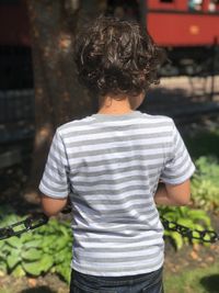 Rear view of woman standing against plants