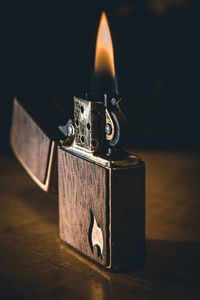 Close-up of burning candle on table