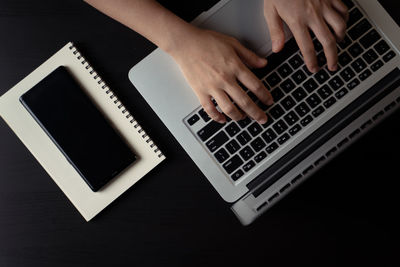 Low section of person using laptop on table