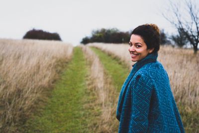 Portrait of woman standing on grassy field