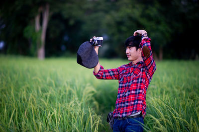 Rear view of man photographing on field