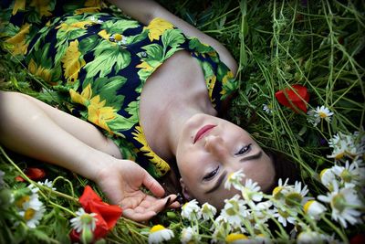 Close-up of young woman lying on field