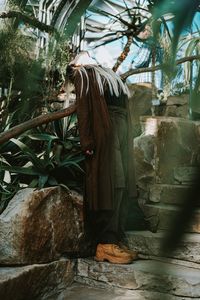 Rear view of man sitting on rock