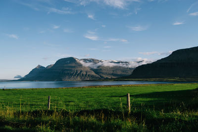 Scenic view of river by mountains against sky