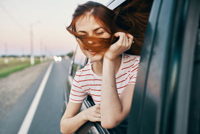 Portrait of beautiful woman standing on road