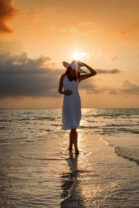 Full length of man standing on beach during sunset