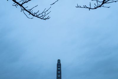 Low angle view of communications tower against blue sky