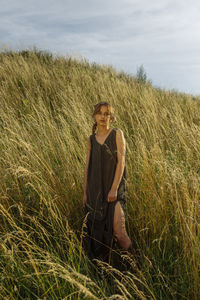 Woman stands on a hill in tall grass