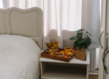 Wooden tray with breakfast and a garland on the bedside table.