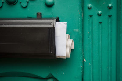 Close-up of mailbox on green wall