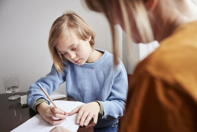 Mother helping daughter with homework