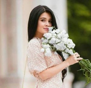 Portrait of woman holding flower bouquet