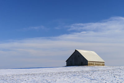 Built structure on snow covered land against sky