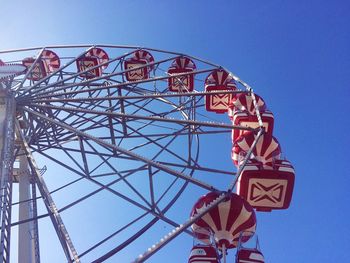 Low angle view of ferris wheel against clear blue sky