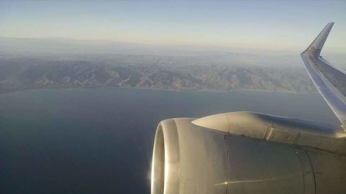 Cropped image of airplane flying over landscape