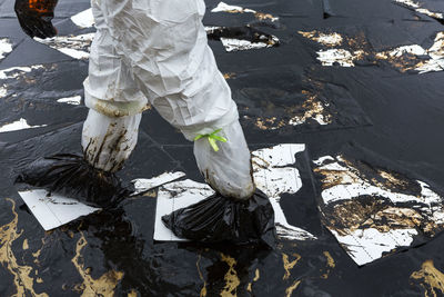 Low section of man walking on oil spill