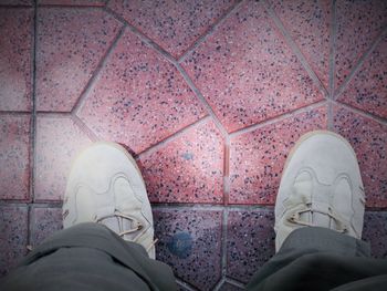 Low section of woman standing on tiled floor