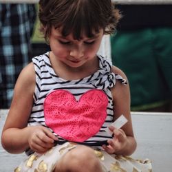 Close-up of cute girl sitting outdoors