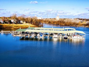 Sailboats moored in lake against sky