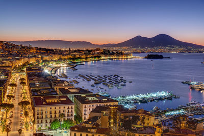 Aerial view of townscape by sea against sky