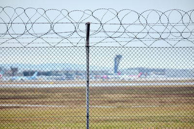 Close-up of chainlink fence against sky