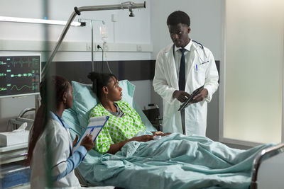 Doctors examining patient in hospital
