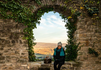 Portrait of woman sitting on wall