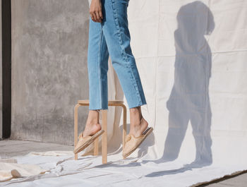 Low section of woman levitating against wall