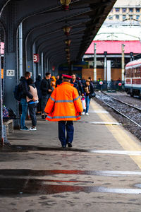 Rear view of people walking on railroad station