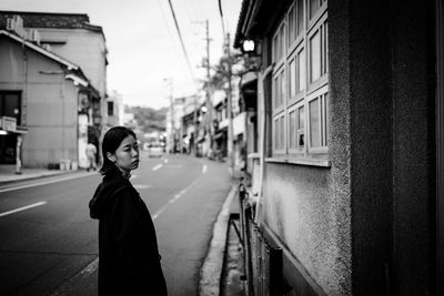 Portrait of woman standing on railroad tracks