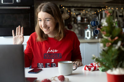 Portrait of smiling woman holding coffee cup on table