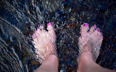 Low section of woman standing in water