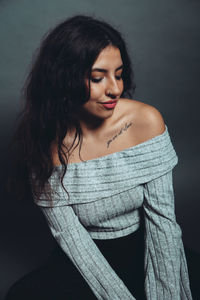 Young woman standing against black background