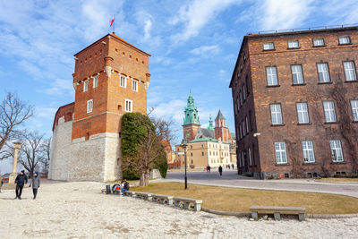 People walking on street by historic building