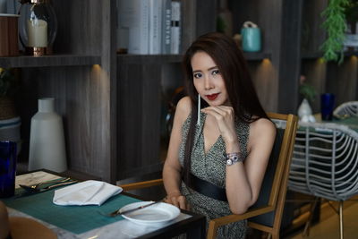 Portrait of woman sitting at table in restaurant