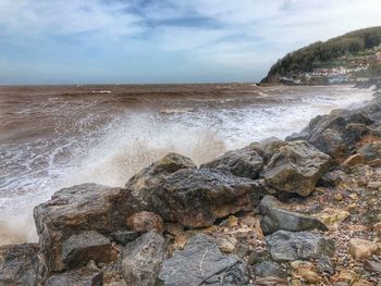 Scenic view of rocks in sea against sky