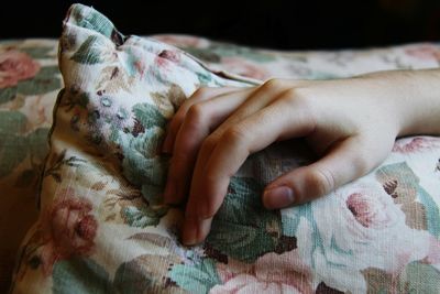 Close-up of hand on pillow