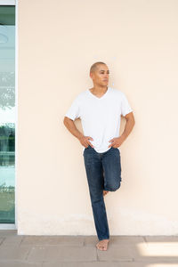 Portrait of young man standing against wall