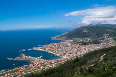 High angle view of townscape by sea against sky