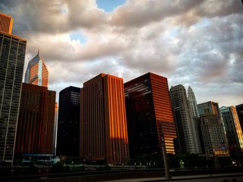 View of skyscrapers against cloudy sky