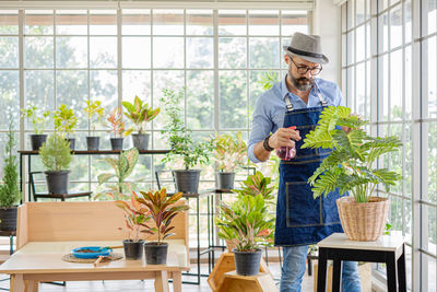 Man watering plants in green house