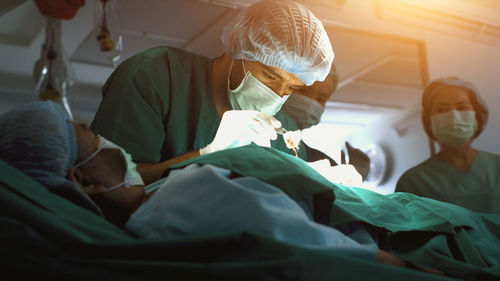 Midsection of doctor examining patient in hospital