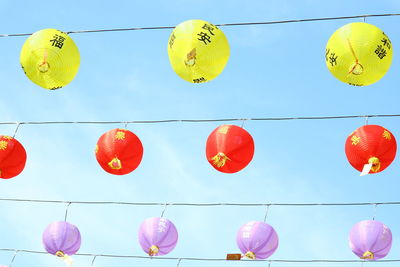Low angle view of lanterns hanging against sky