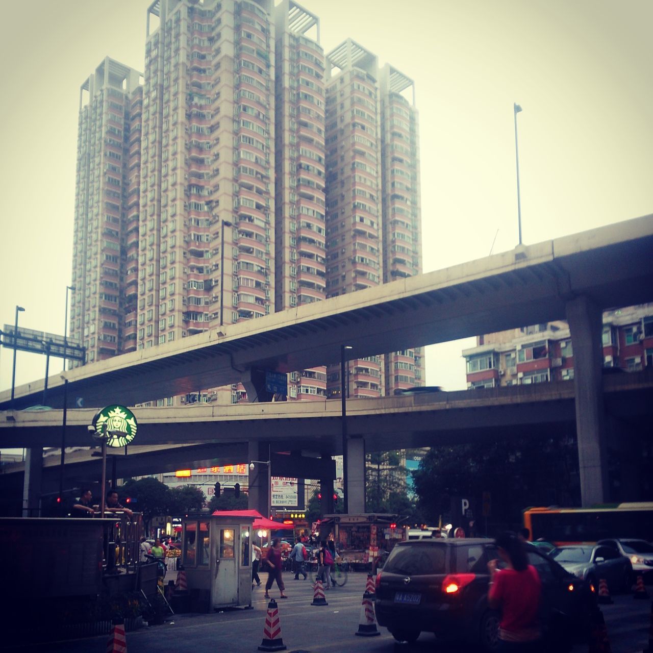 architecture, building exterior, built structure, transportation, car, land vehicle, city, mode of transport, street, city life, city street, street light, traffic, road, sky, incidental people, building, on the move, low angle view