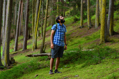 Full length rear view of man walking in forest